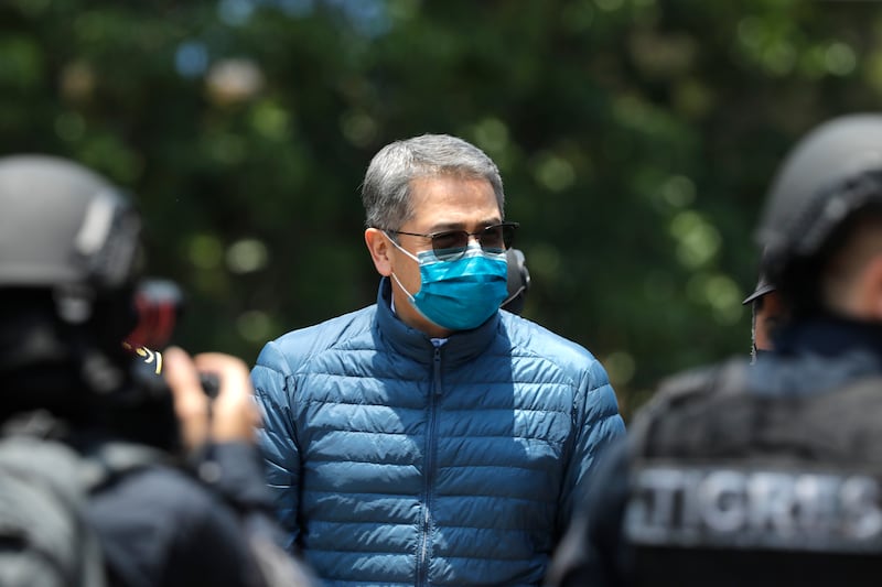 TEGUCIGALPA, HONDURAS - APRIL 21: Former President of Honduras Juan Orlando Hernandez is escorted by Members of the Police Special Forces to be extradited to U.S.to face charges of taking bribes from drug traffickers at Honduran National Directorate of Special Forces on April 21, 2022 in Tegucigalpa, Honduras. Hernandez will stand trial for allegedly aiding the smuggling of hundreds of tons of cocaine to America (Photo by Jorge Cabrera/Getty Images)