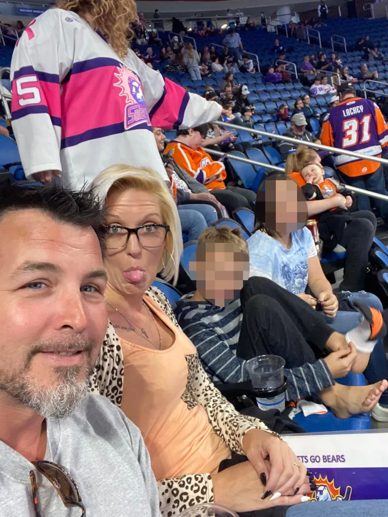 Jason Kenney with Crystal Kenney and her two children at a hockey game in March 2022.