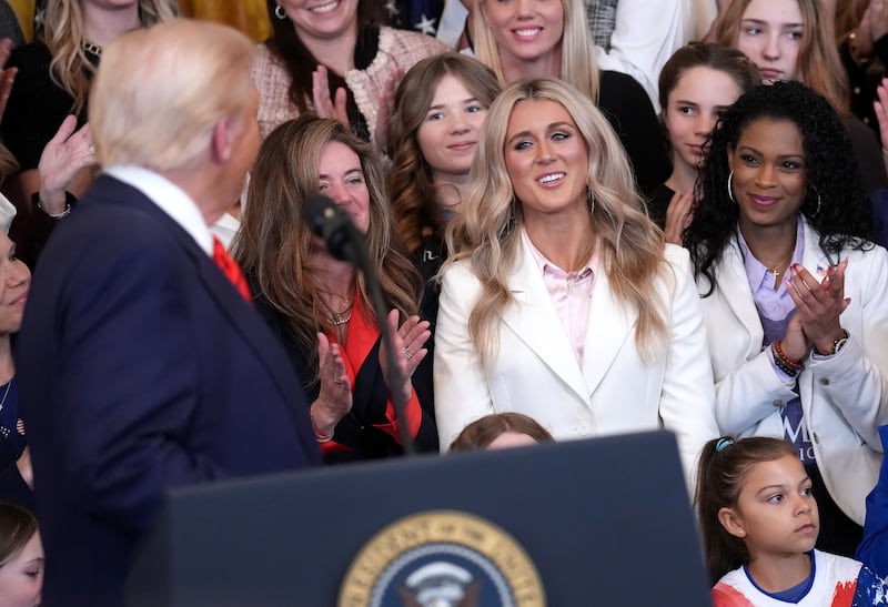Political activist and former competitive swimmer Riley Gaines (center) watches as U.S. President Donald Trump delivers remarks before signing the “No Men in Women’s Sports” executive order in the East Room at the White House on February 5, 2025 in Washington, DC. The executive order, which Trump signed on National Girls and Women in Sports Day, prohibits transgender women from competing in women’s sports and is the third order he has signed that targets transgender people. (Photo by Andrew Harnik/Getty Images)