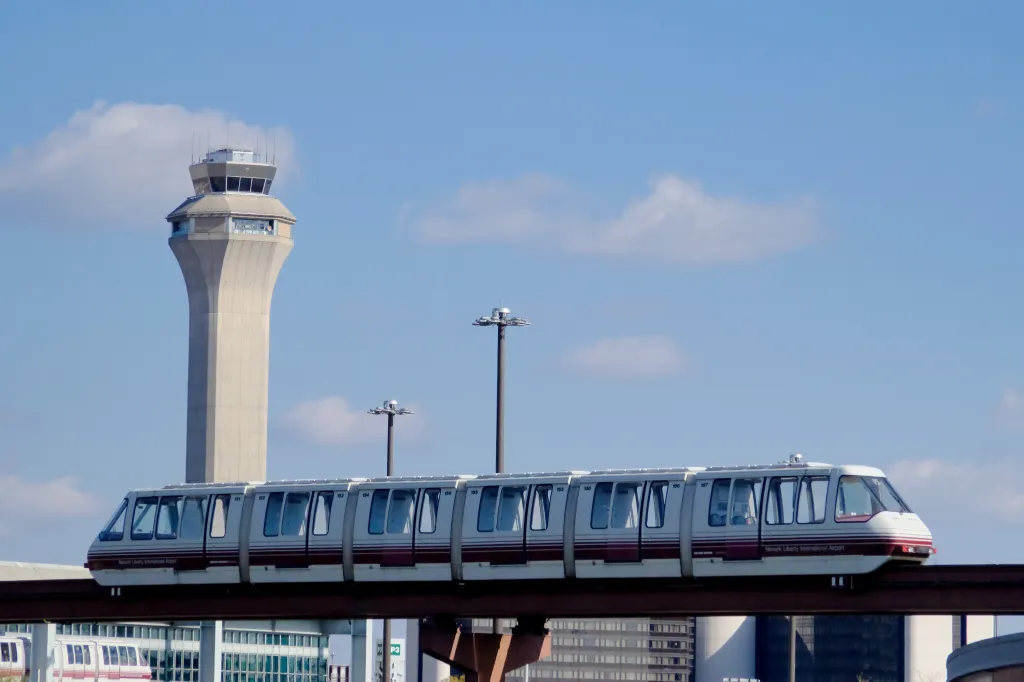 Monorail train at Newark Liberty International Airport with the air traffic control tower in the background.