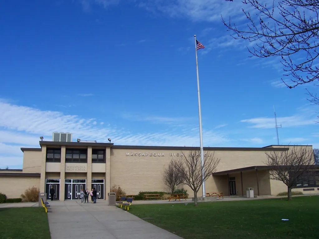 Massapequa High School building with students entering.