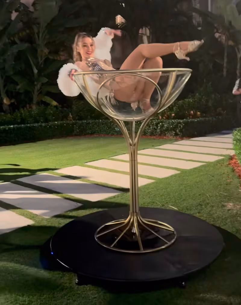 A woman posing in a giant martini glass at the Mar-a-Lago Halloween party.