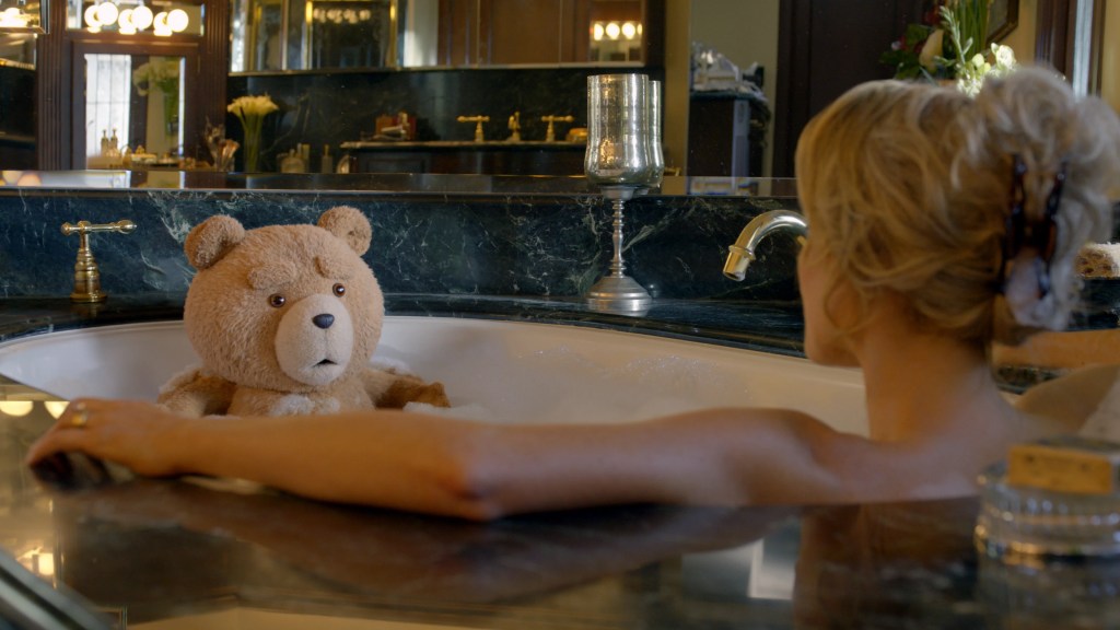 Ted sits in a bath with a woman