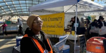 At a farmers market, news on the homeless, hawked by a woman who lived it