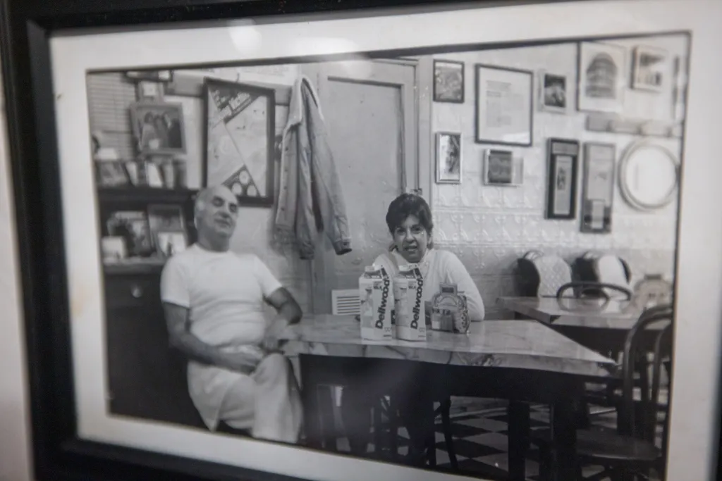 Black and white photo of a man and a woman sitting at a table with drinks.