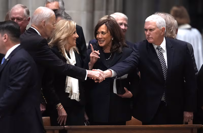 Former U.S. President Joe Biden shakes hands with former Vice President Mike Pence at Thursday’s service.