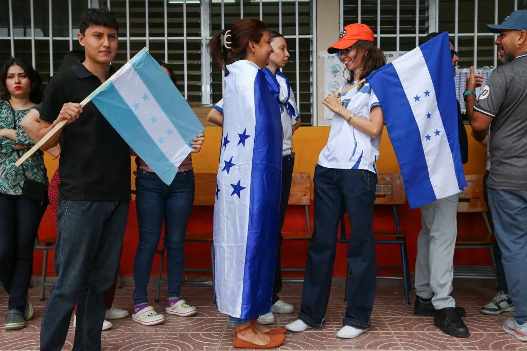 A woman wearing a Honduran flag queues to vote during the general election in Tegucigalpa, Honduras, November 30, 2025. 