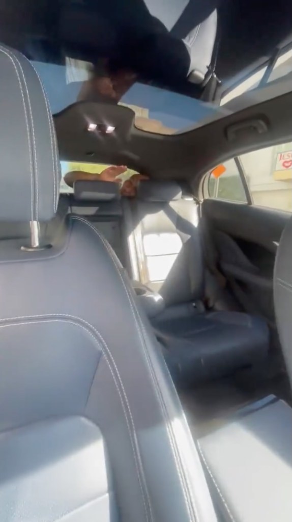 View of car interior from the front passenger seat, showing the back seats and sun roof.