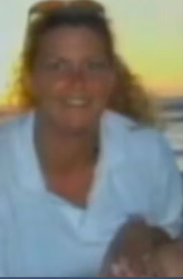 Smiling woman with sunglasses on her head.