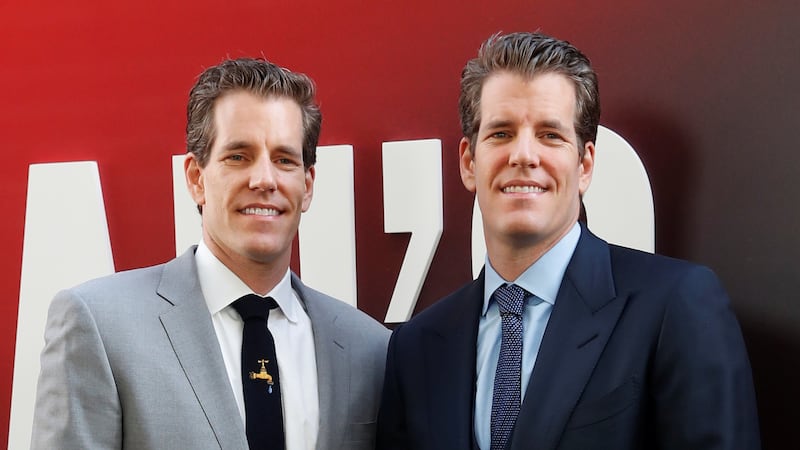 Cameron Winklevoss (L) and Tyler Winklevoss pose as they arrive at the world premiere of the film 