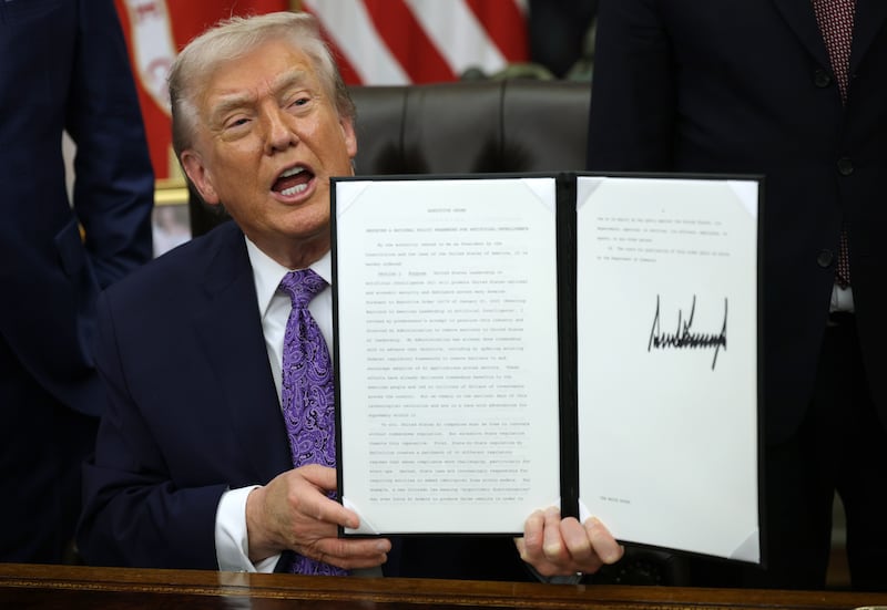 WASHINGTON, DC - DECEMBER 11: U.S. President Donald Trump displays a signed executive order in the Oval Office of the White House on December 11, 2025 in Washington, DC. The executive order curbs states' ability to regulate artificial intelligence, something for which the tech industry has been lobbying. (Photo by Alex Wong/Getty Images)