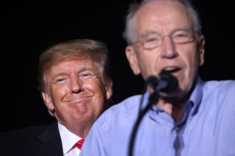 Donald Trump smiles as Chuck Grassley (R-IA) speaks during a rally at the Iowa State Fairgrounds on October 09, 2021 in Des Moines, Iowa.
