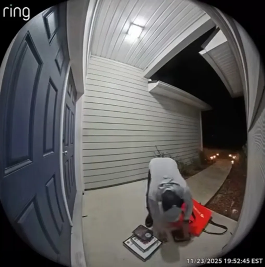 Ring doorbell footage of a person in a gray hoodie and black baseball cap picking up items from the ground and placing them into a red DoorDash bag.