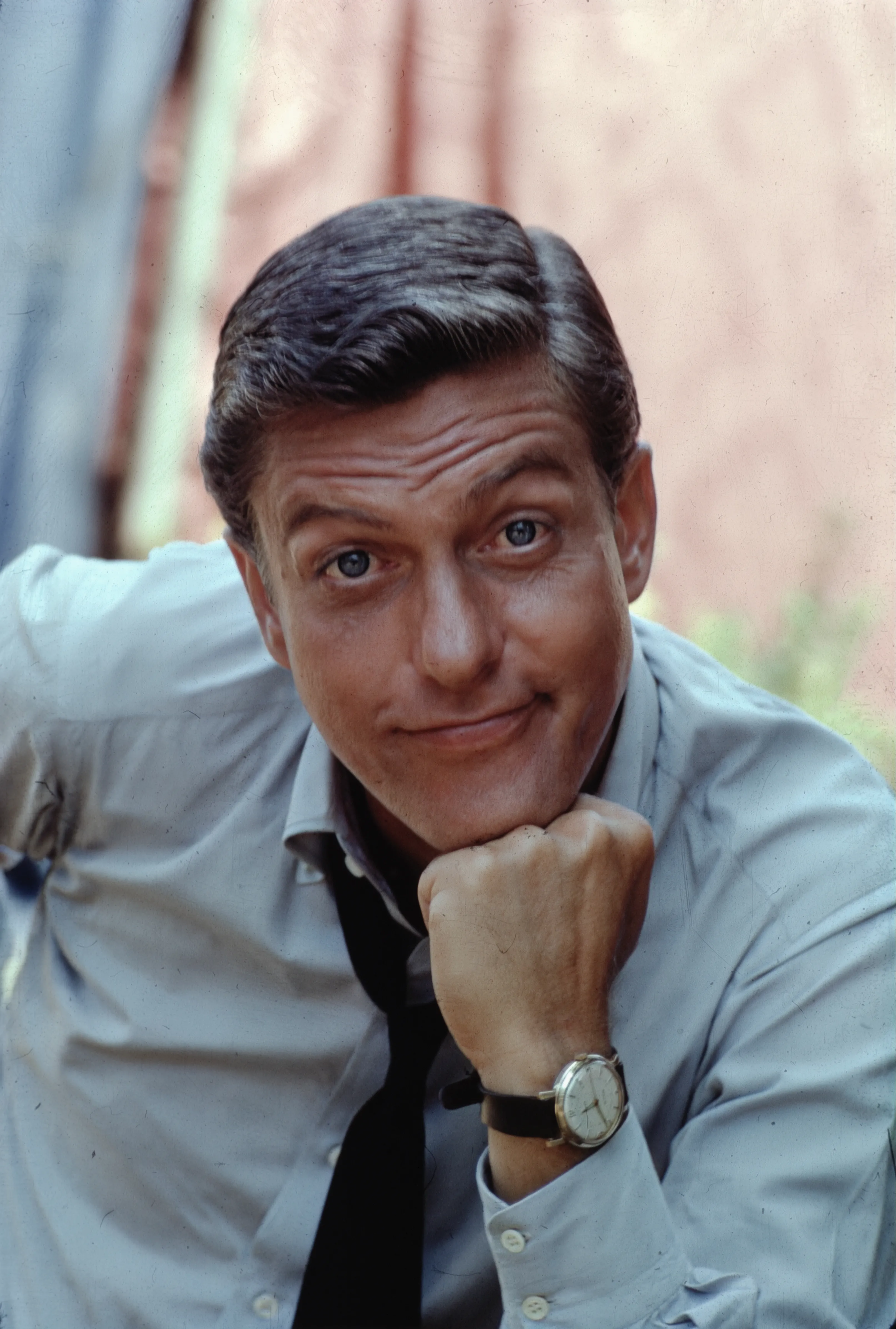 Actor Dick Van Dyke in a blue shirt with his chin resting on his hand.