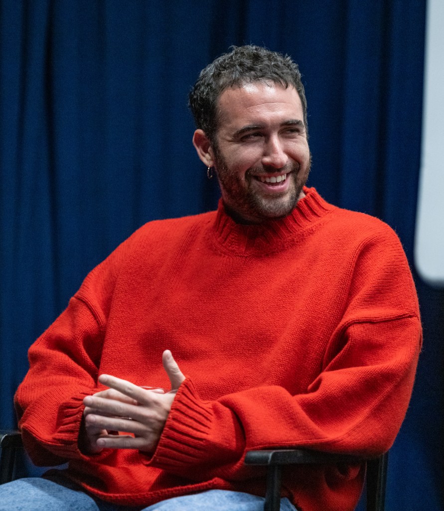 Jordan Firstman in a red sweater, smiling.