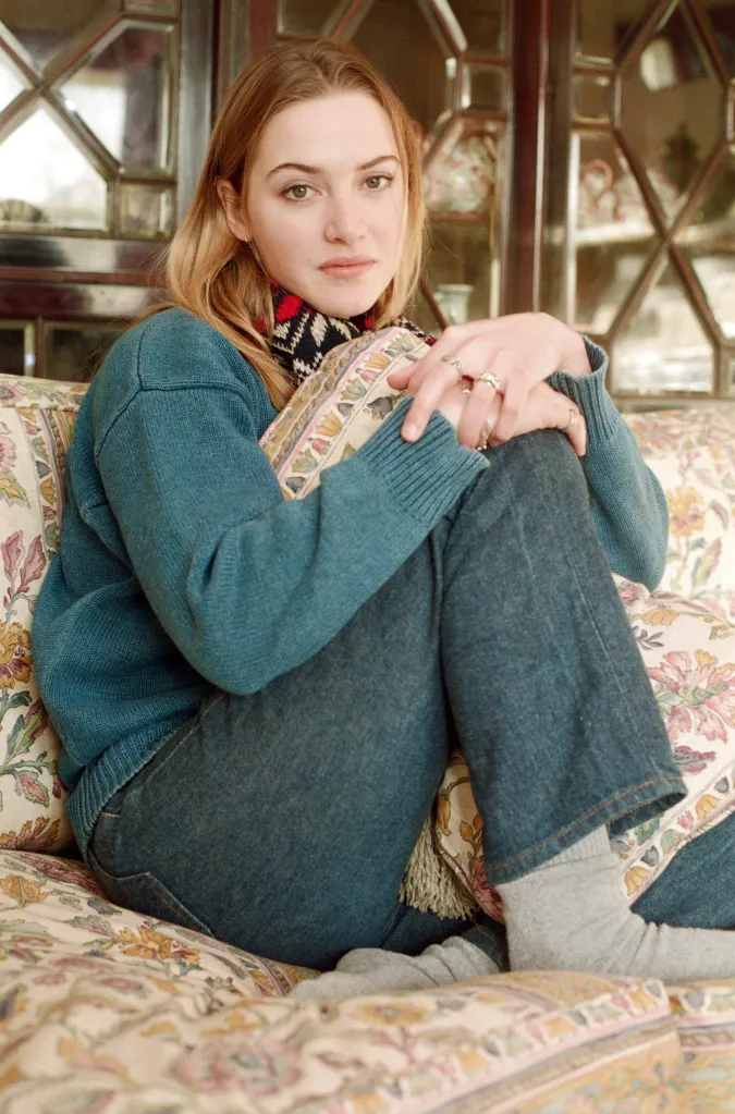 Actress Kate Winslet sitting on a floral couch.