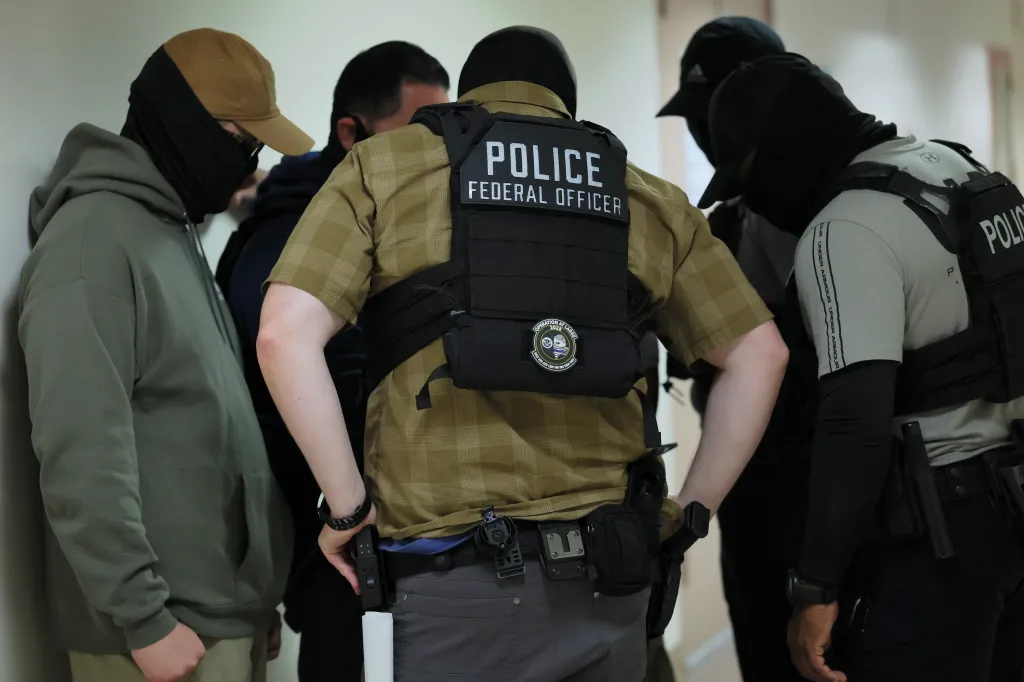 Federal officers detaining immigrants in a courthouse.