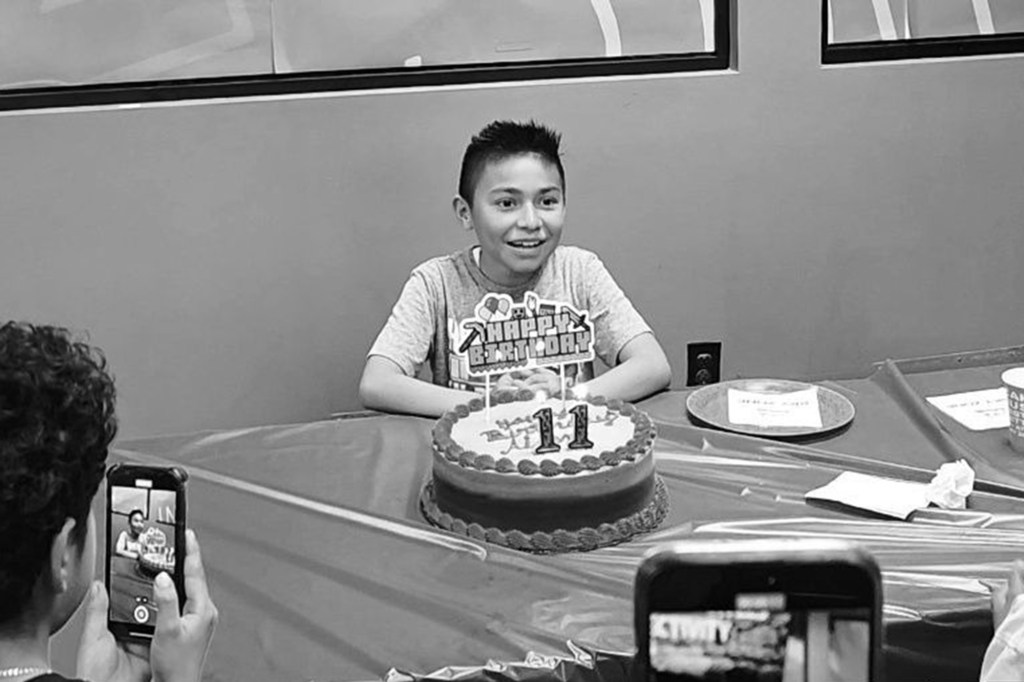 Aiden Antonio Torres de Paz at a birthday party, smiling behind a cake with 