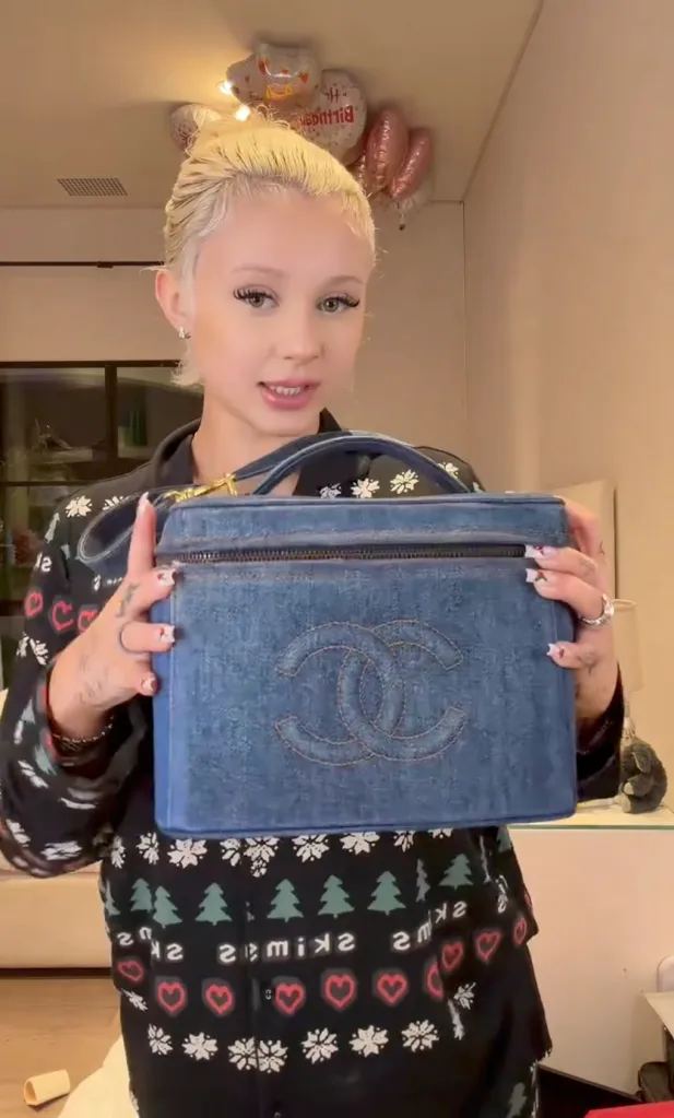 Alabama Barker holding a blue Chanel duffle bag.