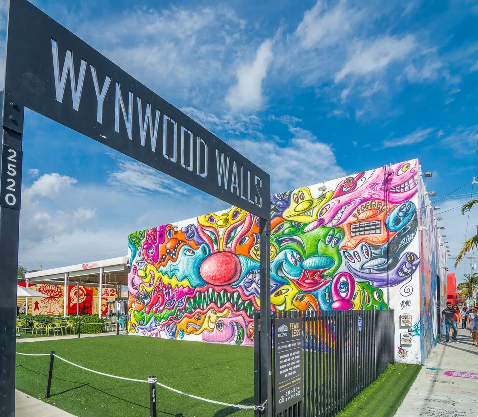 Wynwood Walls sign above a vibrant mural by David Grutman.