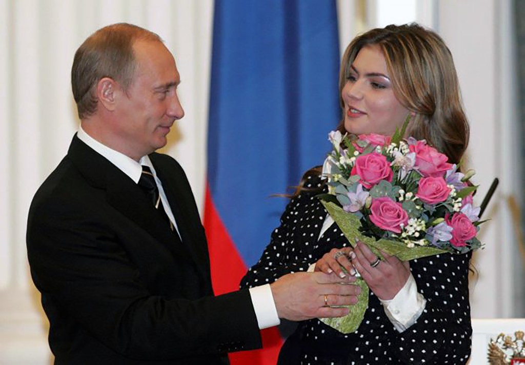 Alina Kabaeva receiving flowers from Vladimir Putin at an event in the Kremlin.