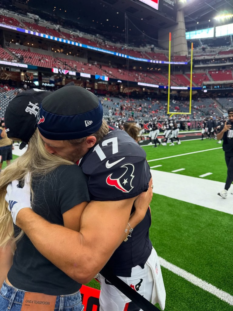 Alix Earle and Braxton Berrios hugging on the football field