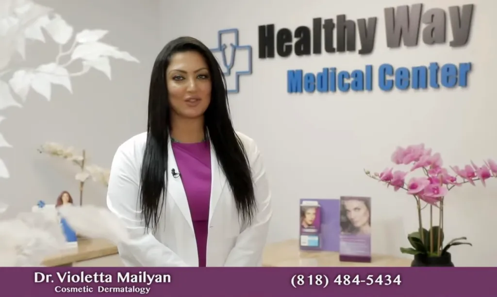 Dr. Violetta Mailyan, a cosmetic dermatologist, stands in front of a sign for Healthy Way Medical Center.