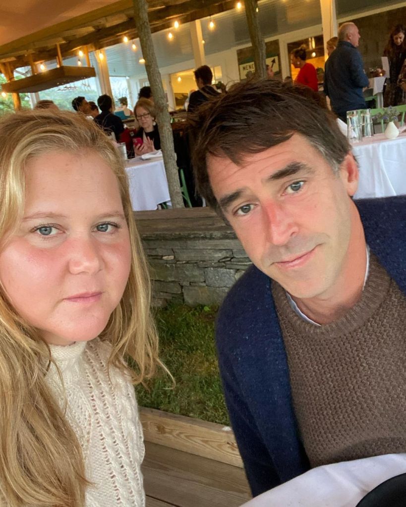 Amy Schumer and a man sitting at a restaurant table.