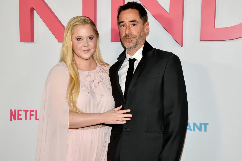 Amy Schumer and husband Chris Fischer on a red carpet.