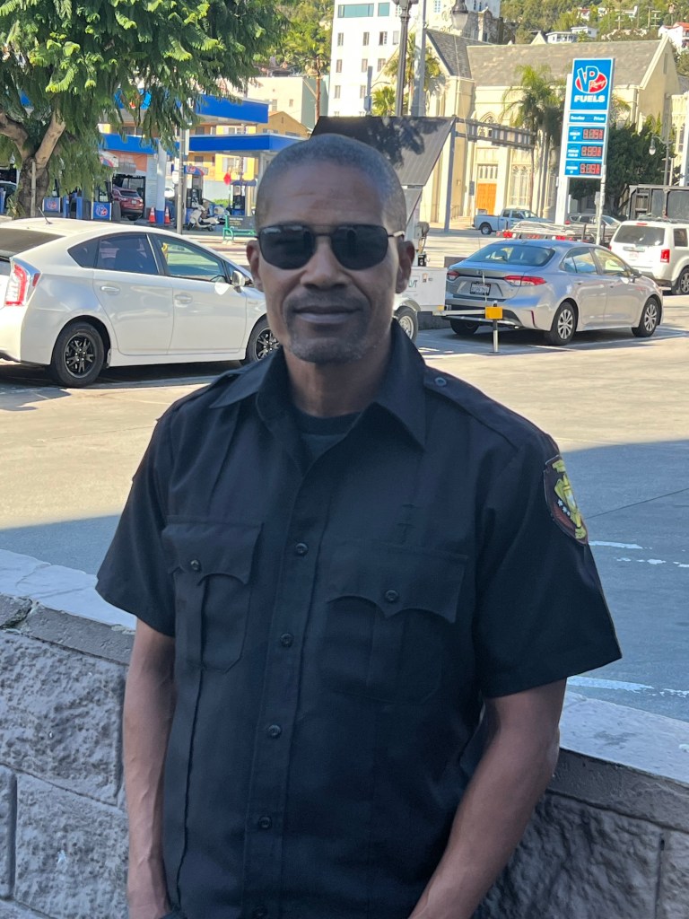 Security guard David Thompson in front of a gas station.