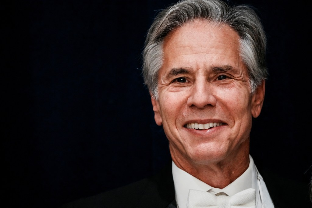 Antony Blinken smiling, wearing a white bow tie and a dark suit.