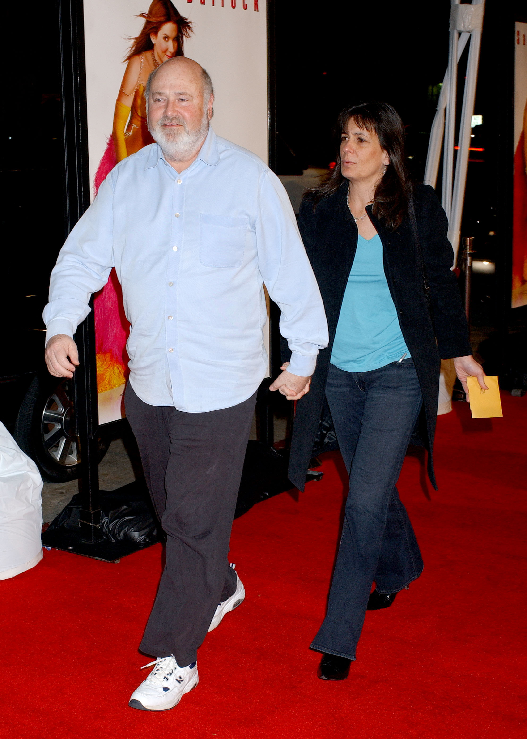 Rob Reiner and wife Michele Singer walking on a red carpet.