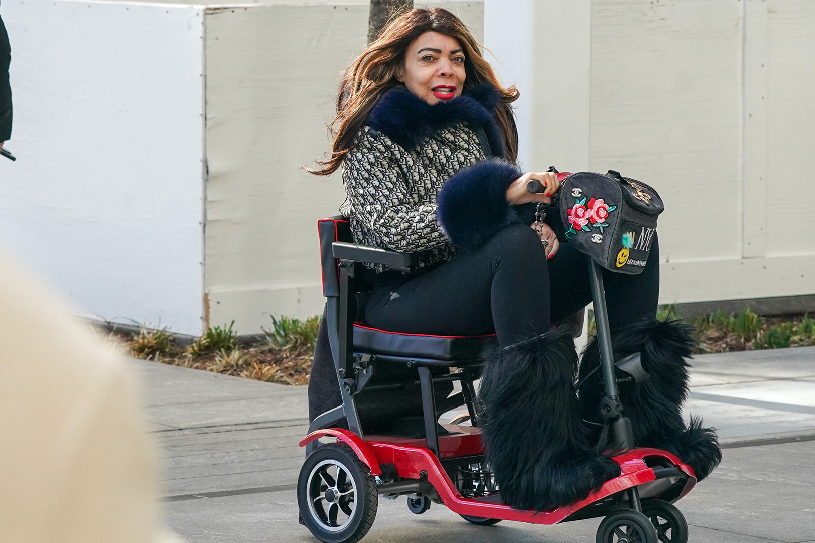 Wendy Williams sitting on a red mobility scooter.