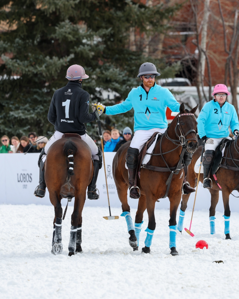 Prince Harry and Nacho Figueras on horseback, shaking hands during a polo match in Aspen.