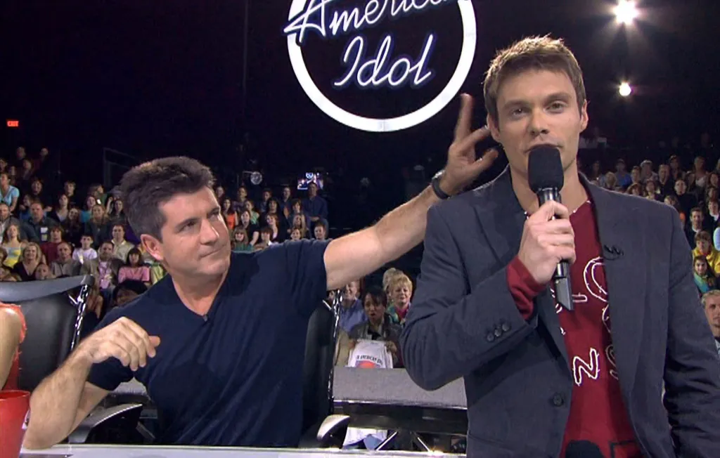 Simon Cowell flicking Ryan Seacrest's ear.