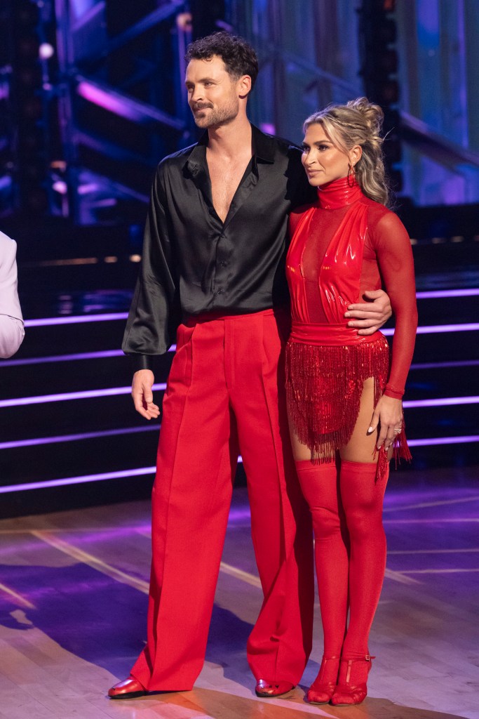 Dylan Efron and Daniella Karagach standing on stage in red and black costumes.