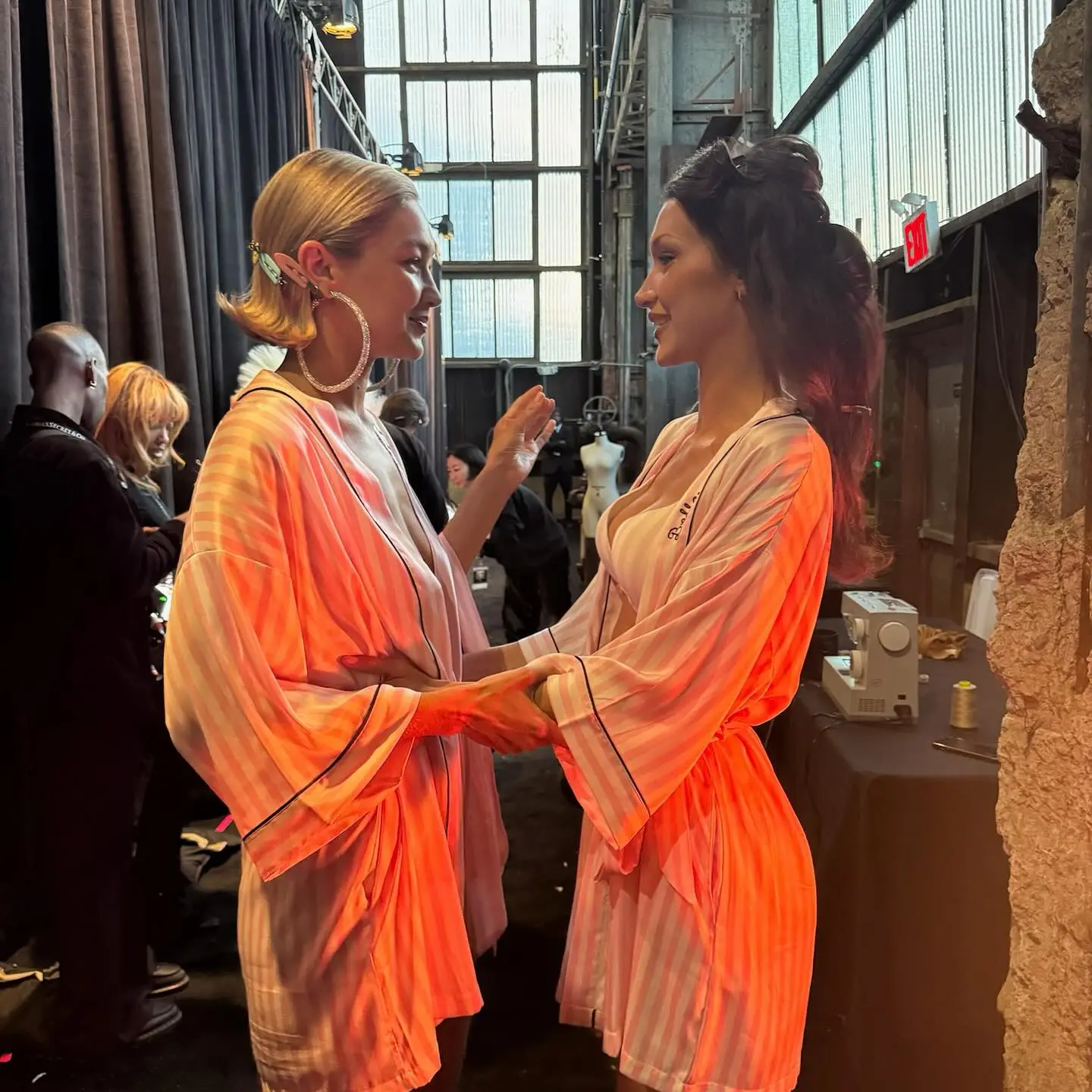 Bella Hadid and Gigi Hadid in pink and white striped robes.