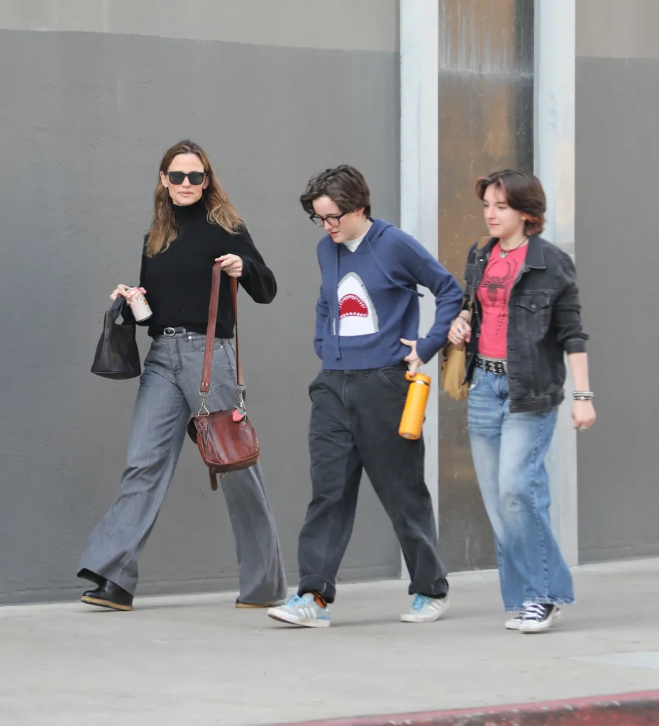 Jennifer Garner, her child Fin, and a friend walking on a sidewalk.