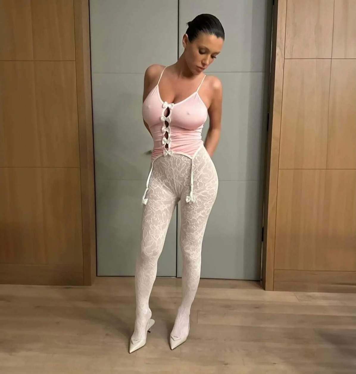 Bianca Censori in a pink top and white lace leggings.