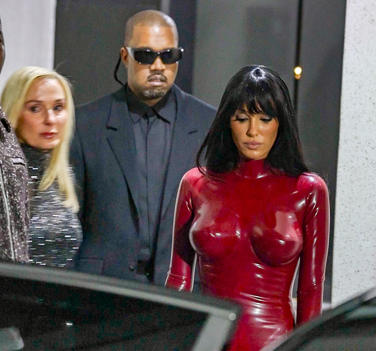 Bianca Censori in a red bodysuit with Kanye West and Alexandra Censori.
