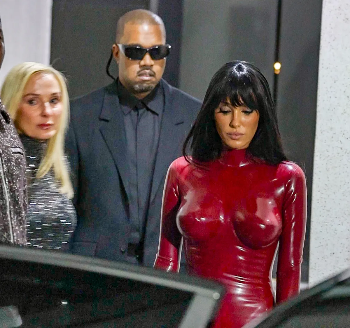 Bianca Censori in a red bodysuit with Kanye West and Alexandra Censori.