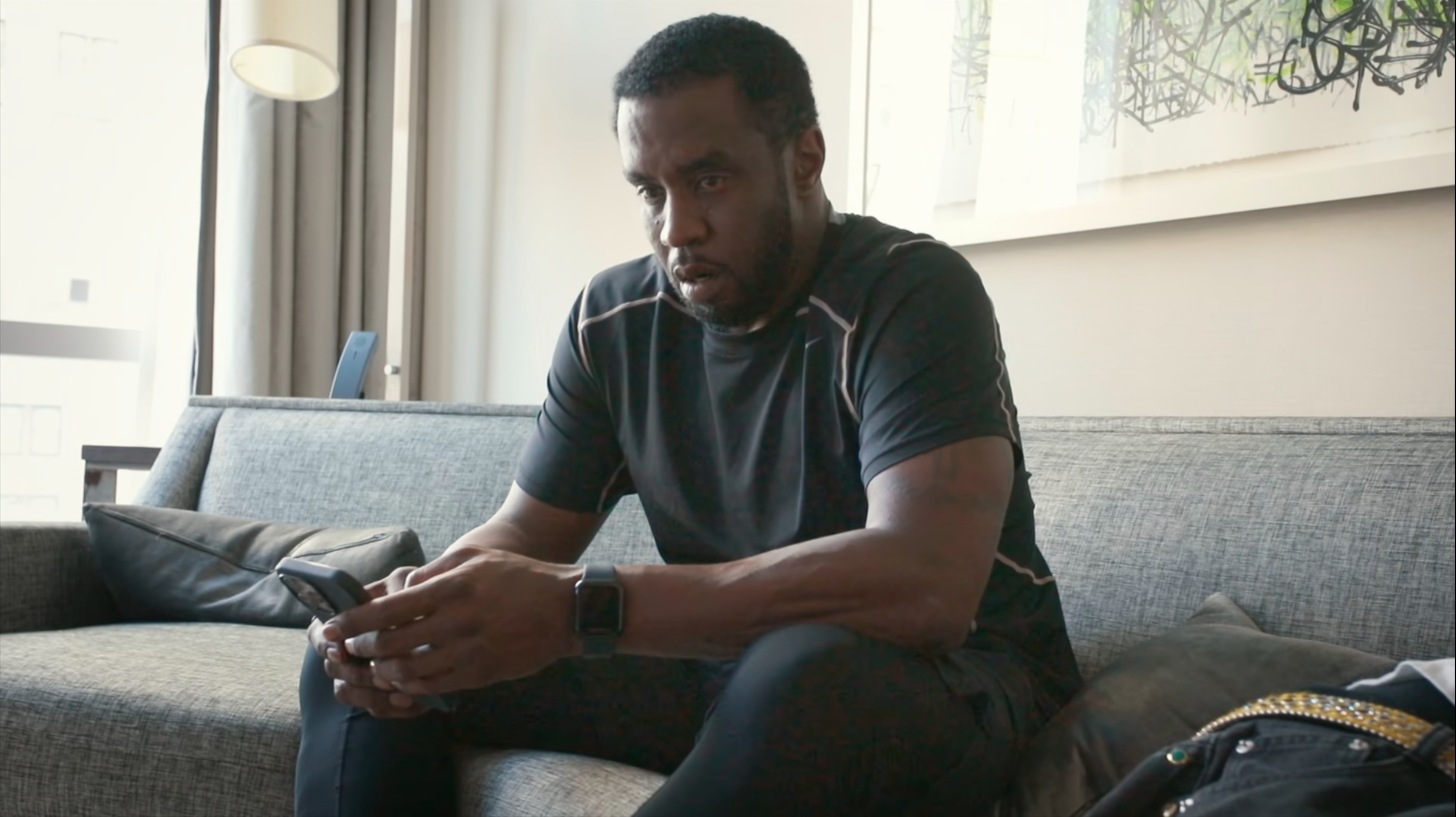Sean “Diddy” Combs looking at his phone in a documentary about his legal battles.