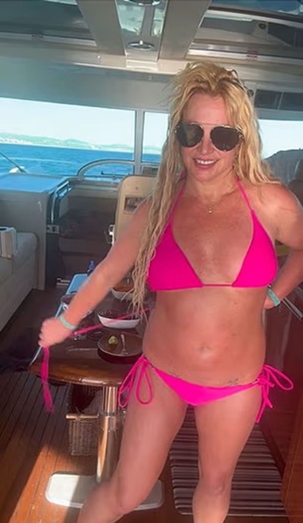 Britney Spears in a hot pink bikini on a boat.