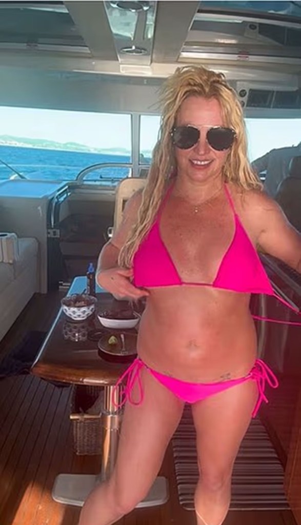 Britney Spears in a hot pink bikini on a boat.