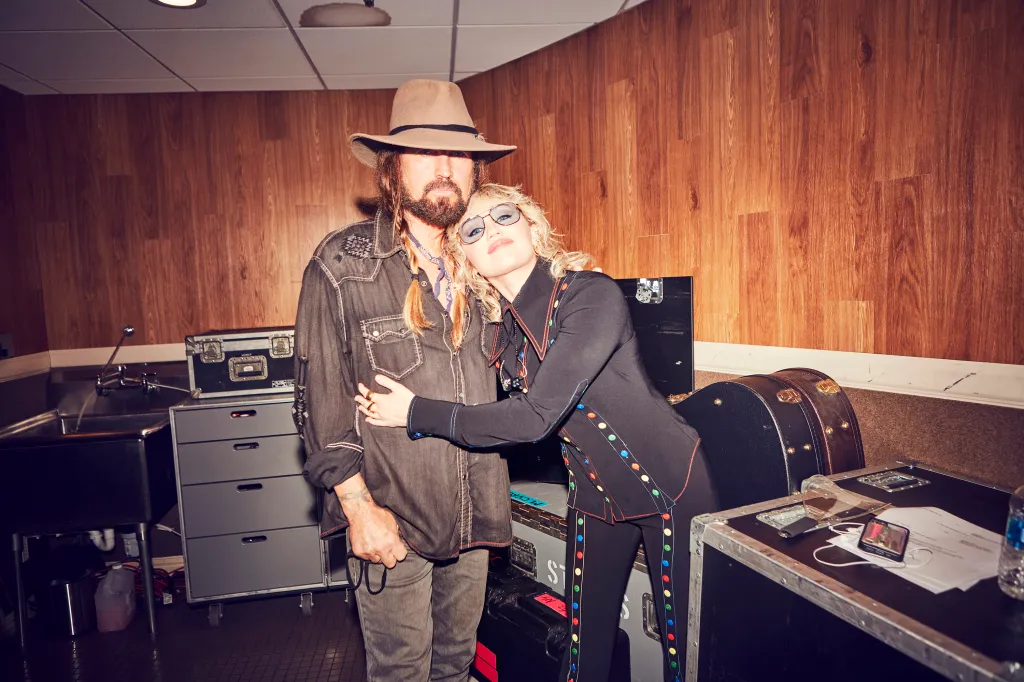 Billy Ray Cyrus and Miley Cyrus hugging.