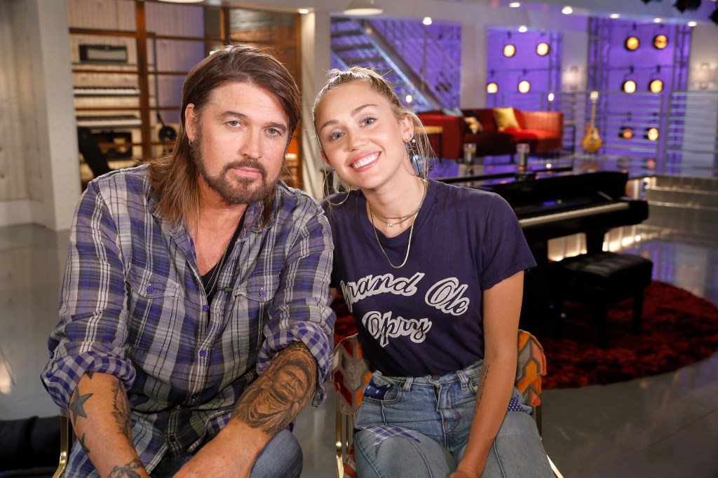 Billy Ray Cyrus and Miley Cyrus smiling and looking at the camera.