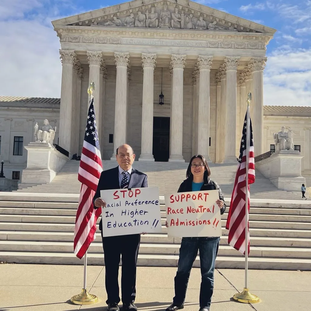 Phil Wong and Yiatin Chu holding signs outside the Supreme Court advocating for an end to affirmative action.