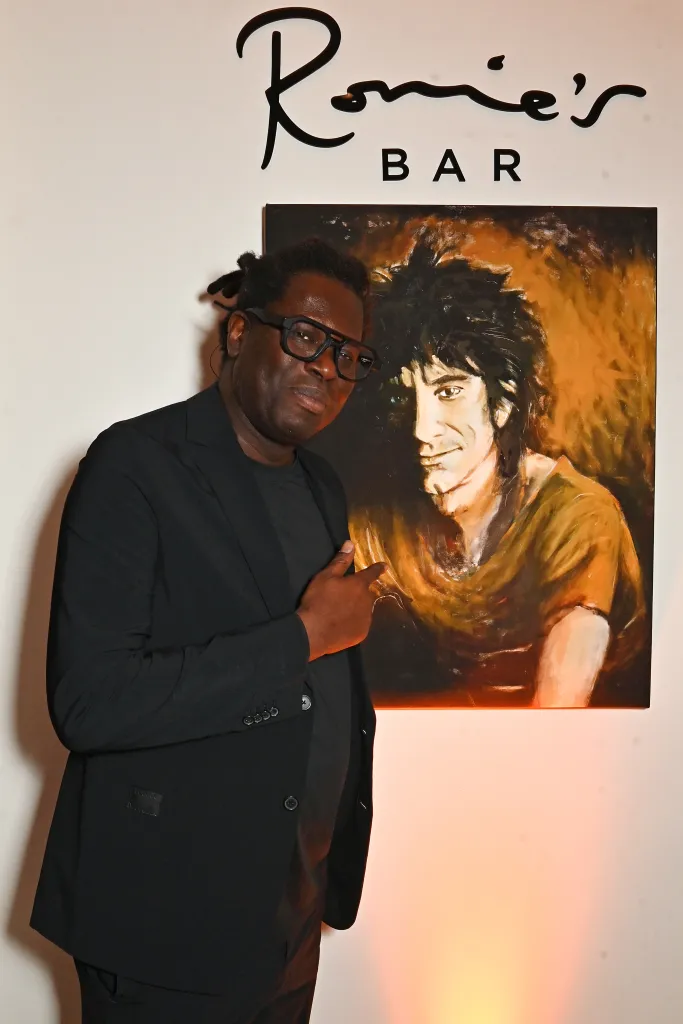 Bradley Theodore standing next to a painting of a man.