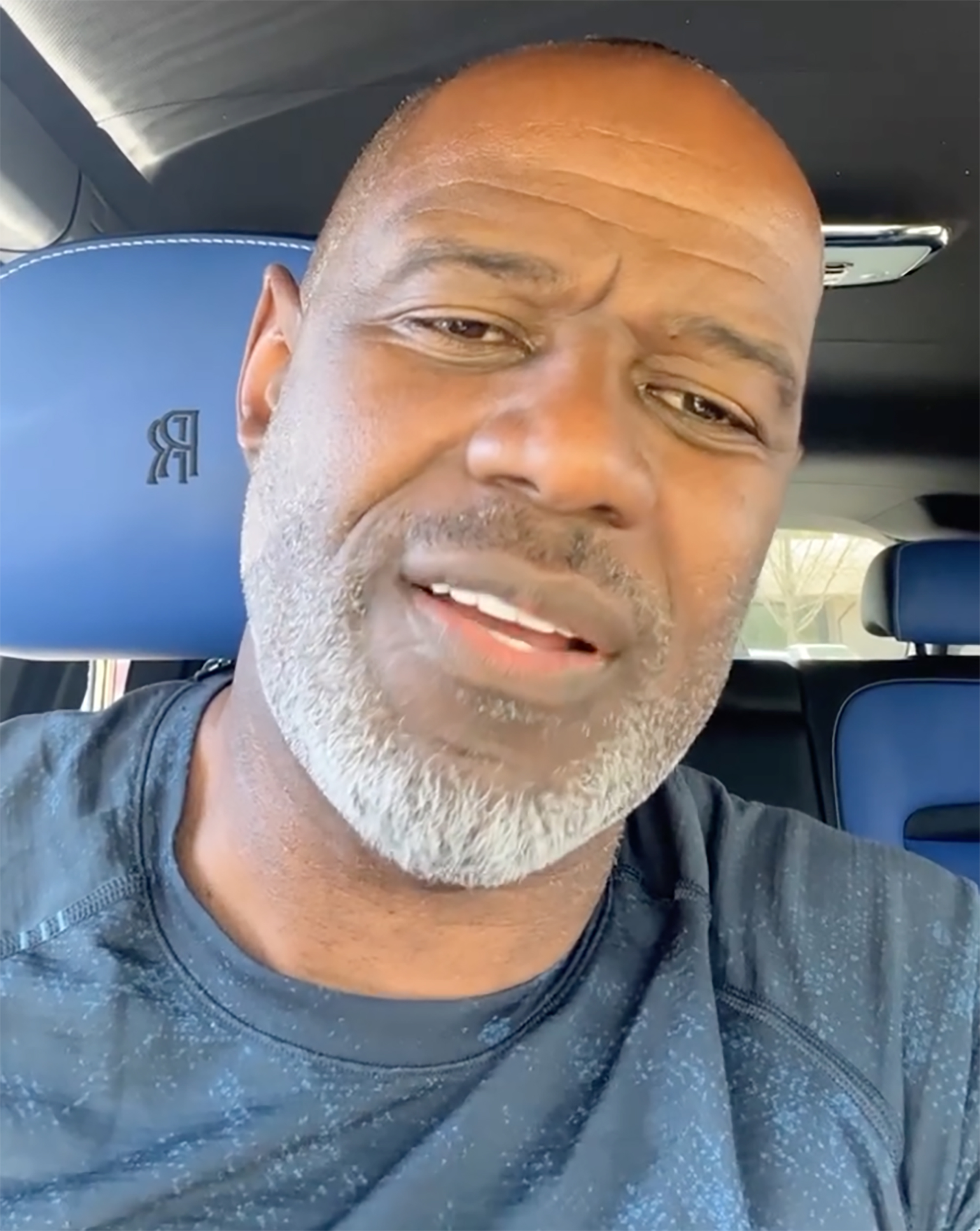 Brian McKnight looking towards the camera, with a blue car seat featuring the Rolls-Royce logo visible behind him.