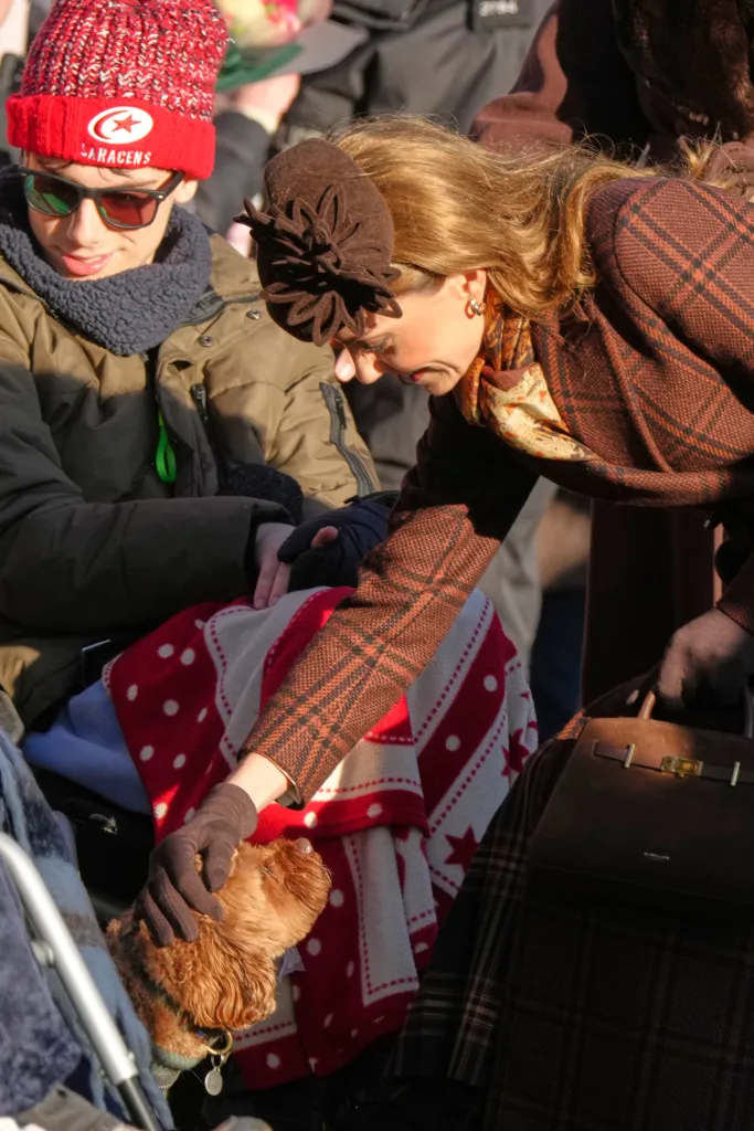 Britain's Kate, Princess of Wales, strokes a dog while meeting members of the public after attending the Christmas Day service.